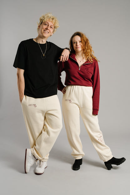 Schwarzes T-Shirt mit gesticktem Ton-in-Ton-Logo auf der Brust. Das Motiv zeigt ein stilisiertes „T“ in einem Kreis mit Lorbeerzweigen. Das Shirt besteht aus glatter Baumwolle, hat einen lockeren Schnitt und verkörpert einen cleanen, modernen Streetwear-Stil.